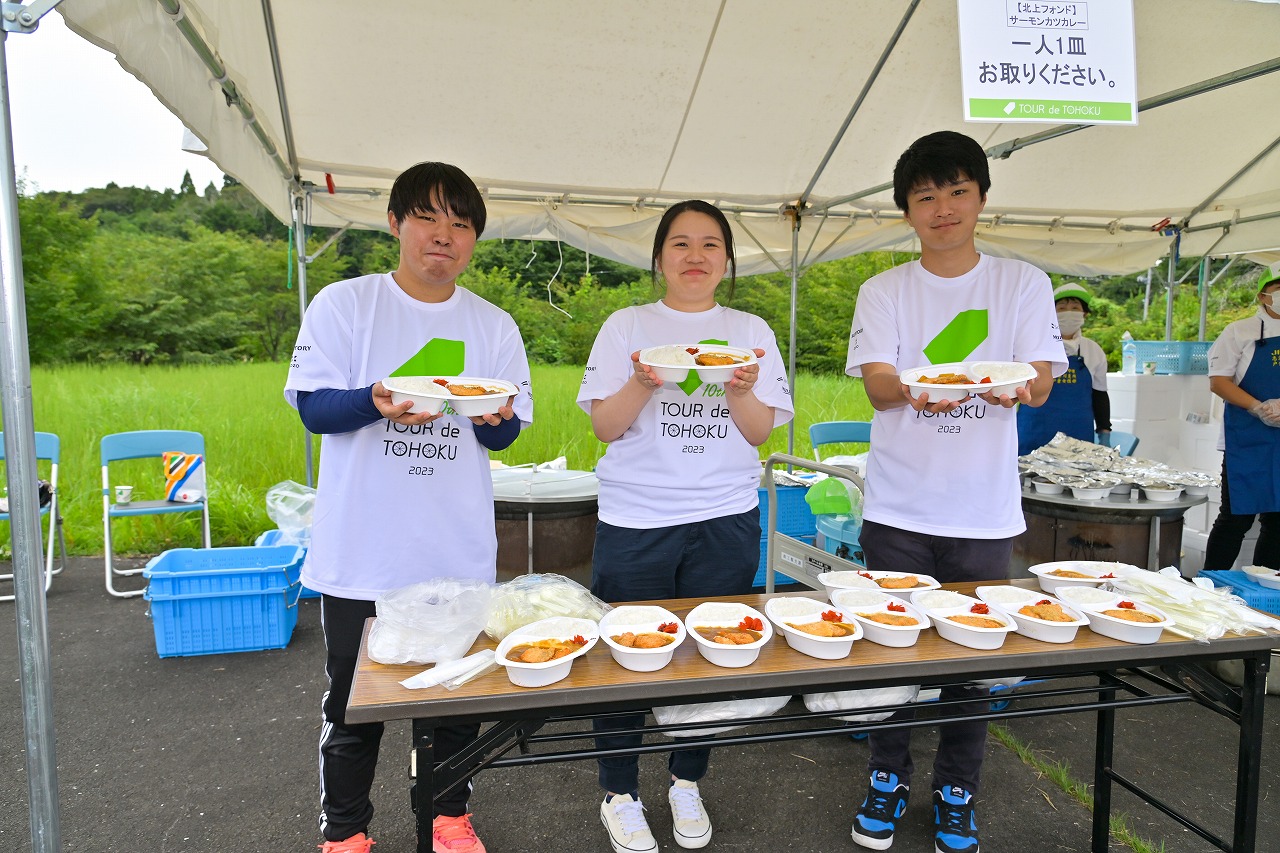 エイドでカレーを提供するボランティア3人の写真